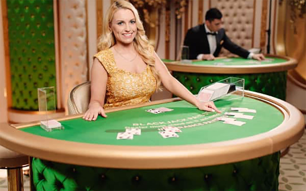 Live blackjack dealer holding cards at Betbit